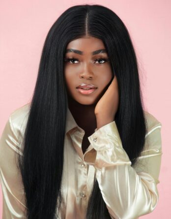 Stunning portrait of a young woman in a silk blouse on a pink background.